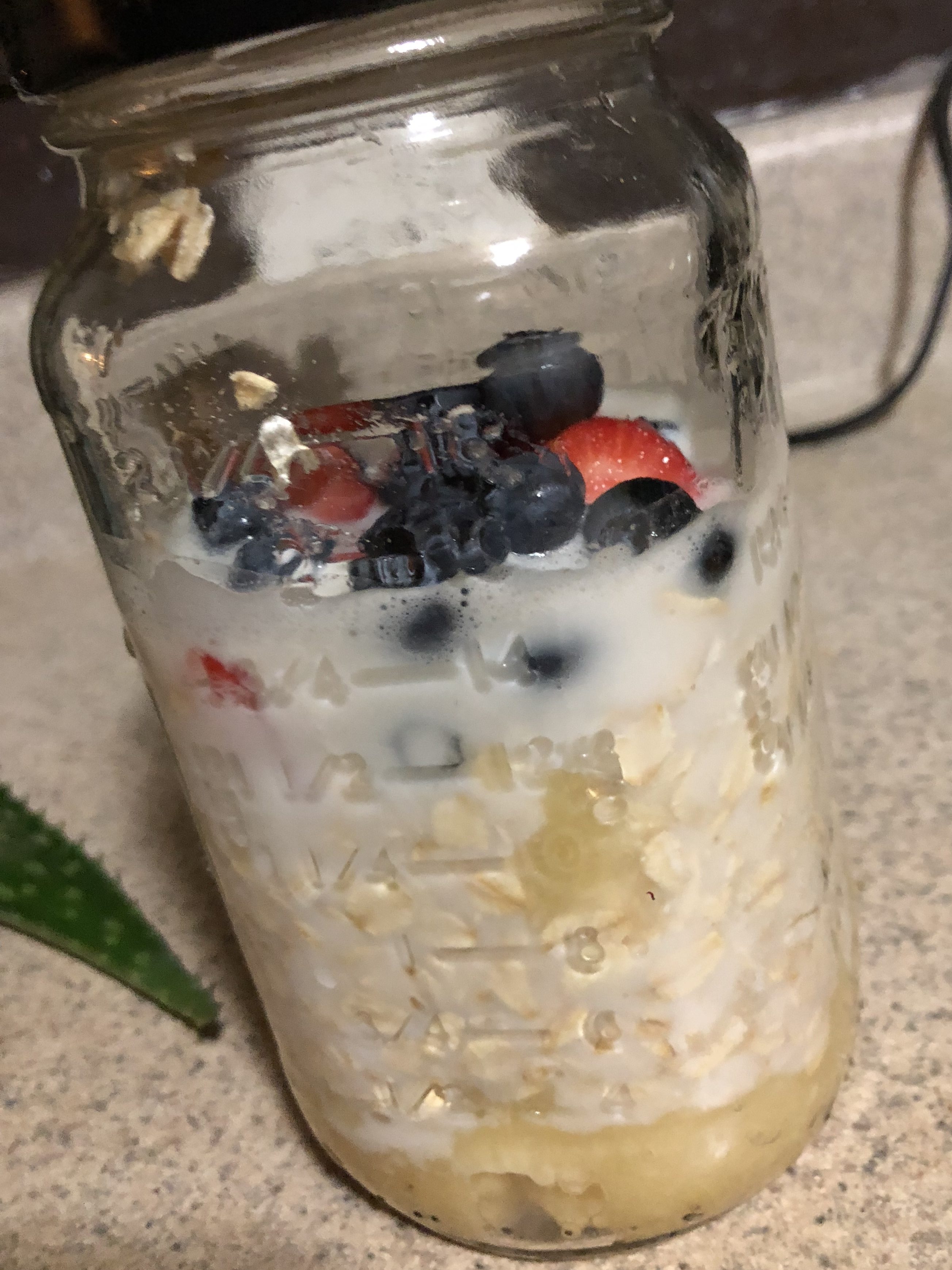 a jar of overnight oats with strawberries and blueberries